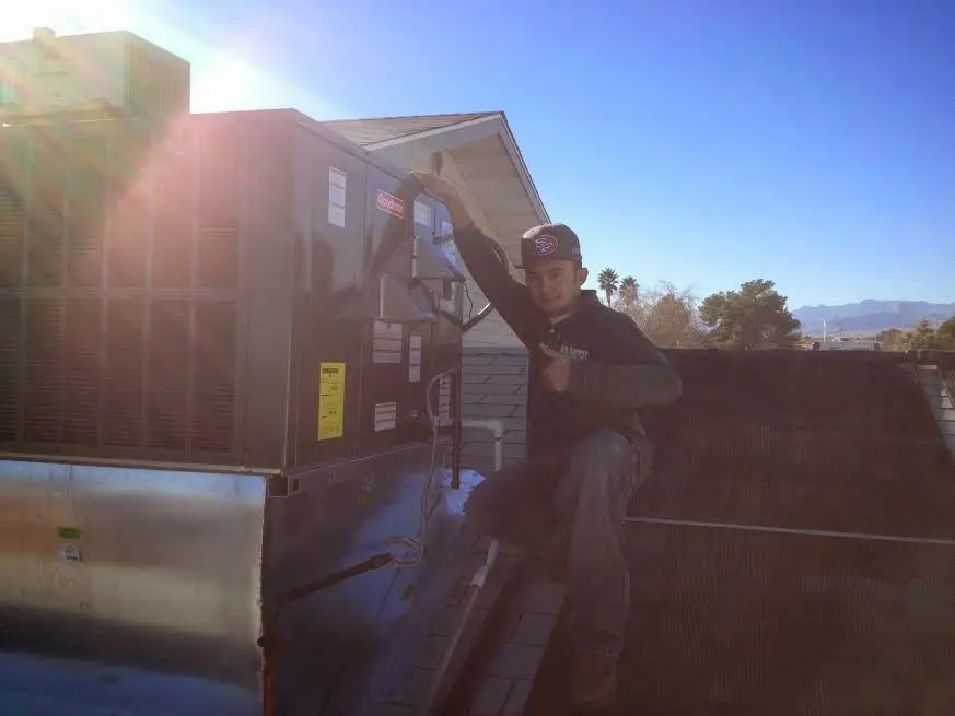HVAC technician performing Boiler Repair on a rooftop unit in Baltimore
